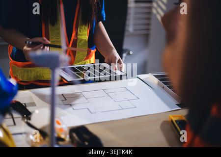 Due tecnici ispezionano i rack server nel data center con tablet e cavo in fibra ottica. Il tecnico e lo specialista discutono dei lavori di manutenzione nel data center Foto Stock