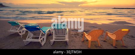 Spiaggia la sera con chaise longue Foto Stock