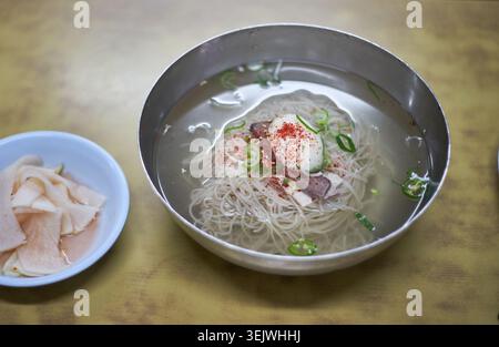 Questa immagine mostra il naengmyeon di Pyongyang, con spaghetti di grano saraceno in un brodo fresco e trasparente. Cattura in modo splendido un ambiente raffinato e autentico Foto Stock