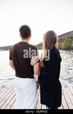 La coppia si trova vicino a un molo di legno Foto Stock