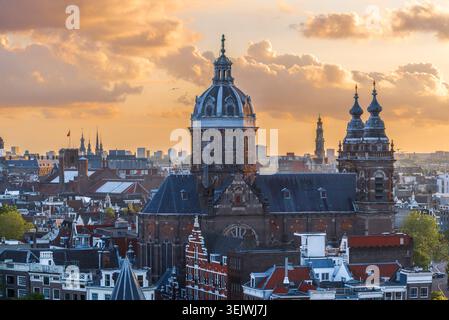 Paesaggio urbano di Amsterdam con la Basilica di San Nicola al tramonto, vista aerea dei tetti del centro storico, Paesi Bassi Foto Stock
