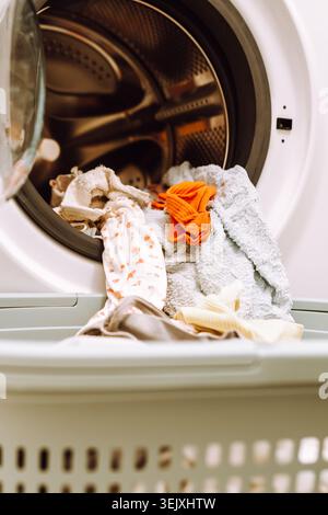 Posizionare gli articoli lavati dalla lavatrice in un cestello Foto Stock