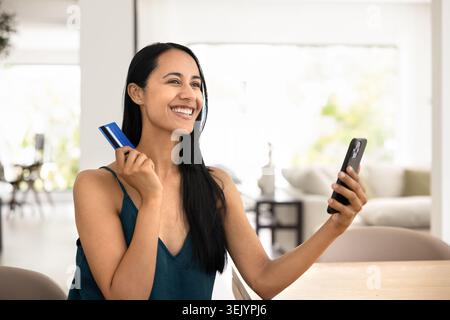 Donna felice shopping online con carta di credito Foto Stock