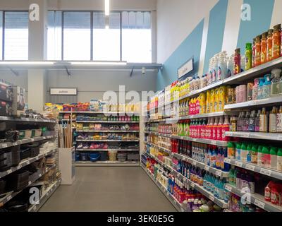 Vescovato, Italia - 2 dicembre 2025 Un'ampia selezione di prodotti per la pulizia, detergenti e prodotti per la casa sono ordinatamente disposti su più ripiani Foto Stock