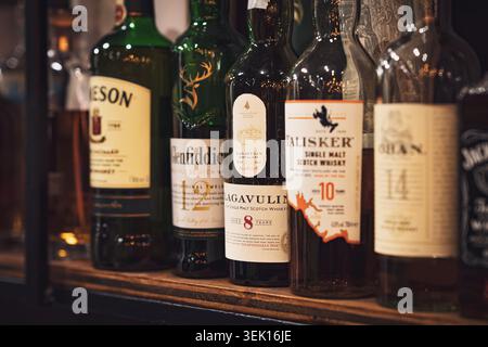 Padova, italia 29 maggio 2026: Bottiglie di whisky di marchi famosi come jameson, glenfiddich, lagavulin e talisker in piedi su un ripiano di legno in pa Foto Stock