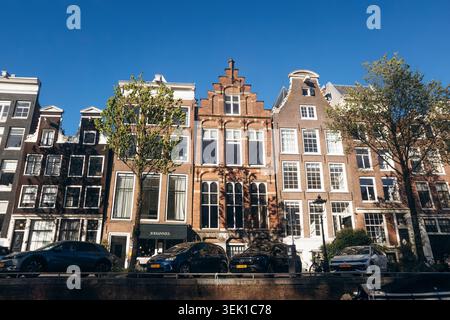 Amsterdam, Paesi Bassi - 18 aprile 2026: Fila di tradizionali case olandesi sui canali con storiche facciate a spiovente lungo un canale nel centro di Amsterdam, sotto c Foto Stock