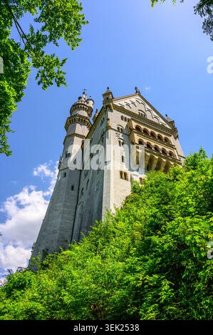 Schwangau, Germania - maggio 31 2026: Prospettiva dall'angolo basso dello storico castello di Neuschwanstein, con la sua facciata torreggiante e i balconi in pietra risvegliati Foto Stock