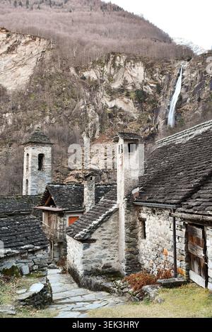Case storiche in pietra e cascata nel paese di Foroglio, Valle di Bavona, Ticino, Svizzera Foto Stock