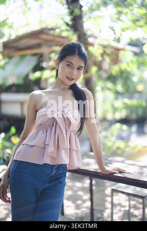 Ritratto di una bella donna asiatica sorridente, ritratto di benessere, felicità all'aperto Foto Stock