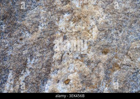 Granito ruvido, rocce ignee, fondo in pietra. Struttura cristallina dettagliata di questo materiale durevole utilizzato per piani di cucina, pavimenti, Foto Stock