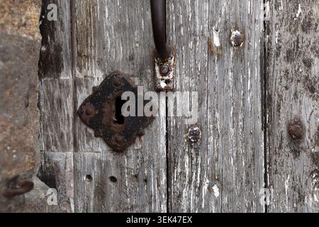 Serratura arrugginita e dettaglio della porta in legno resistente agli agenti atmosferici a Mont Saint-Michel, Normandia, Francia. Foto Stock