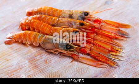 Aragosta norvegese grezza su tavola di legno Foto Stock