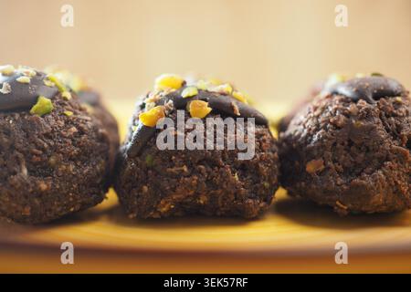 Prelibatezze di cioccolato su un piatto di legno con le noci sopra Foto Stock