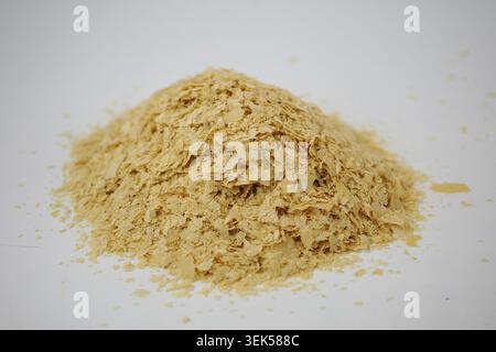 Fiocchi nutrizionali di lievito in un piccolo mucchio su una superficie Foto Stock