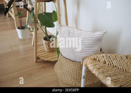 Cuscino decorativo su cesto in tessuto in un moderno spazio abitativo Foto Stock