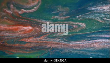 Spruzzi di liquido. Vernice a emulsione. Blu arancio sfocato verde brillante acqua brillante texture mix su sfondo acrilico astratto. Foto Stock