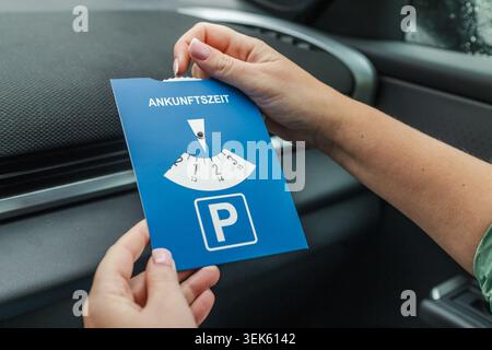 Autista donna con disco di parcheggio europeo blu all'interno di un veicolo moderno Foto Stock