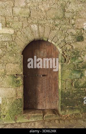 Antica porta in legno posta in un muro di pietra intemprata al castello di Kuressaare, Kuressaare, Saaremaa, Estonia, Europa. Foto Stock