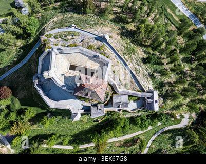 Vista aerea del castello di Tarasp su una collina rocciosa circondata da lussureggianti alberi verdi e sentieri tortuosi Scuol, Graubunden, Svizzera. Foto Stock