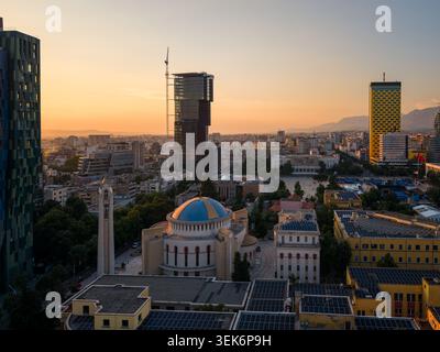 Veduta aerea della Resurrezione della Cattedrale ortodossa di Cristo e dei moderni grattacieli al tramonto a Tirane, Contea di Tirana, Albania. Foto Stock