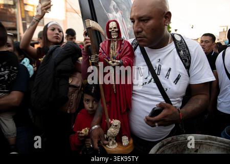 Un uomo tiene una statua di Santa Muerte tra una folla di devoti fuori dal santuario popolare del santo nel quartiere di Tepito a città del Messico, Messico, il 1° aprile 2026. I devoti si riuniscono il primo giorno di ogni mese al santuario di via Alfareria nel quartiere di Tepito per recitare il rosario e presentare offerte a Santa Muerte, un santo popolare che personifica la morte. Il movimento è cresciuto in modo significativo dalla fondazione del santuario nel 2001, con seguaci che usavano statue di colori diversi e offerte specifiche per fare varie petizioni per la protezione e i miracoli. (Foto di Xavier Duarte/Middle East Images/St Foto Stock