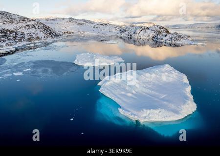 Vista droni dell'iceberg bianco e del ghiaccio blu turchese sotto la superficie nel tranquillo fiordo d'acqua artica vicino a Ilulissat, Avannaata, Groenlandia Foto Stock