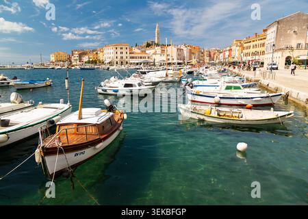 Piccolo porticciolo con barche ormeggiate e passerella sul lungomare nella città vecchia del porto di Rovigno, Istria, Croazia. Foto Stock