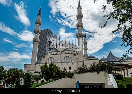 La Moschea di Namazgah a Tirana, Albania, presenta grandi cupole e alti minareti, con un moderno grattacielo che si erge dietro di essa sotto un cielo blu. Foto Stock