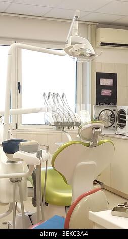 Moderna sala trattamenti odontoiatrica dotata di sedia dentista, lampada per esami e attrezzature odontoiatriche professionali in un ambiente sanitario pulito Foto Stock