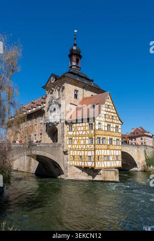 Bamberga, Baviera, Germania - 7 aprile 2026: Il vecchio municipio di Bamberga si erge sul fiume con un cielo blu brillante Foto Stock