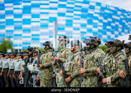 Il personale militare armato che indossa attrezzature mimetiche tattiche si trova in formazione per la sicurezza durante un evento sportivo di massa allo stadio Foto Stock