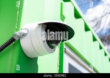 Telecamera a cupola di sicurezza per esterni montata sulla parete verde Foto Stock