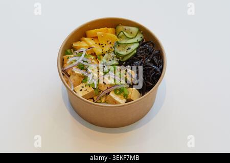 Tofu, ananas, mango, sottaceti di cetriolo, alghe nere o funghi di legno, cipolla rossa, cipolla primaverile, semi di sesamo, base di riso, condimento piccante. Foto Stock
