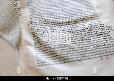 Vista ravvicinata di un libro antico che mostra il testo latino stampato su carta invecchiata. Foto Stock