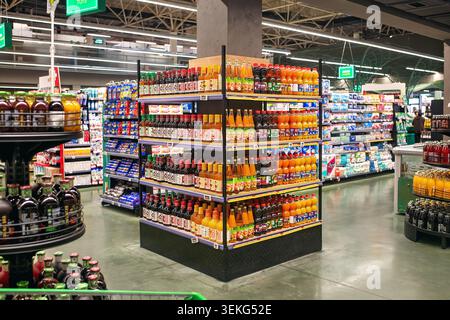 Batumi, Georgia - 30 maggio 2026: Colorate file di succhi e bevande analcoliche in uno stand all'interno di un moderno negozio di alimentari. Foto Stock