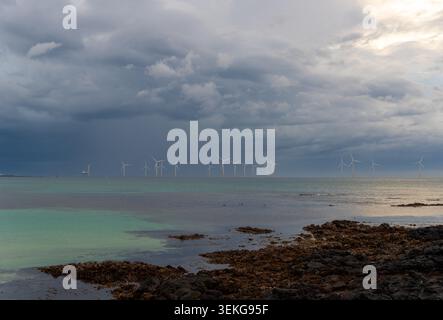 Jeju Offshore Wind Farm al crepuscolo con nuvole spettacolari e mare turchese visto dalla costa vulcanica di Aewol, Corea del Sud Foto Stock