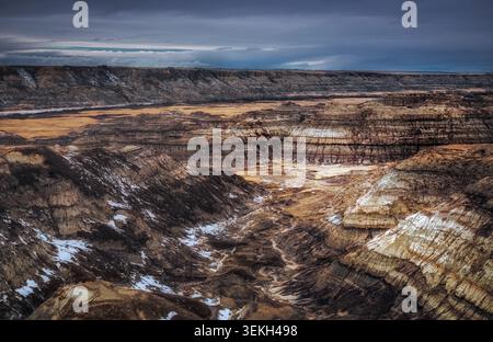 Vasti paesaggi delle Badlands dell'Albertan che mostrano spettacolari formazioni rocciose ed erosione sotto un cielo nuvoloso Foto Stock
