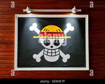 palu, Indonesia - 31 maggio 2026: Logo Jolly Roger incorniciato dei pirati del cappello di paglia dalla famosa serie manga e anime giapponese One Piece, esposto su una parete di pannelli di legno Foto Stock