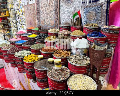 Colorato assortimento di spezie, frutta secca e frutta secca esposto in cesti tradizionali in un autentico mercato arabo nella storica Dubai Foto Stock