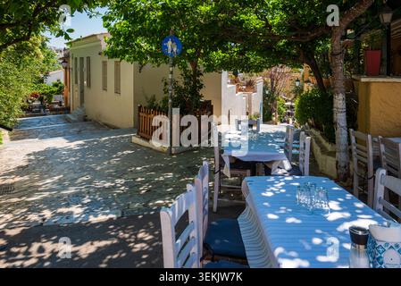 Vista mattutina da una terrazza ristorante nel quartiere Plaka di Atene, affacciata su gradini in pietra Foto Stock