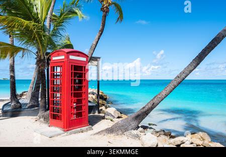 Telefono britannico rosso a Dickenson Bay Beach, Antigua, Caraibi Foto Stock