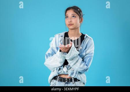 Donna asiatica pensiva che guarda verso l'alto nel futuro della pianificazione dello spazio Foto Stock