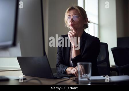 Esperta di affari donna matura e premurosa che lavora alla scrivania dell'ufficio Foto Stock