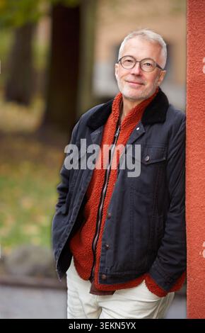 Ritratto di un anziano sorridente appoggiato al muro Foto Stock