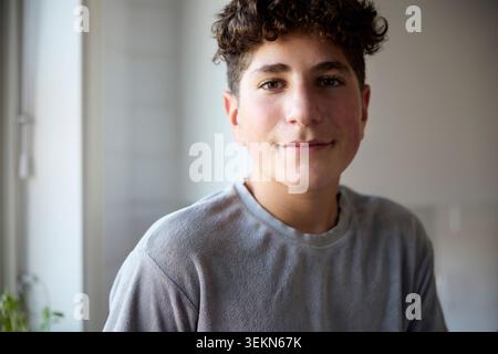 Ritratto ravvicinato di un ragazzo sorridente a casa Foto Stock