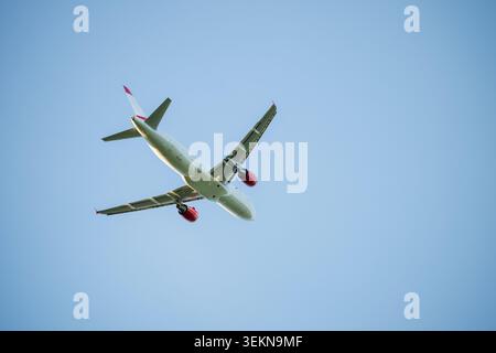 Basso angolo di vista aereo commerciale battenti contro il cielo blu Foto Stock