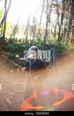Donna sorridente che passa il tempo libero nella foresta Foto Stock