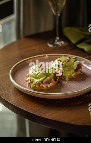 Uova benedict con prosciutto e hollandaise Foto Stock