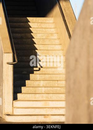 Scale in cemento con corrimano in metallo alla luce del sole Foto Stock