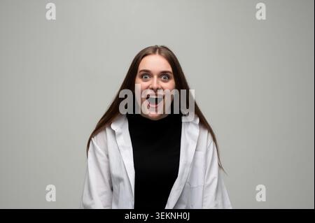 Giovane donna con un'espressione eccitata e sorpresa, bocca aperta che mostra shock, gioia e stupore Foto Stock